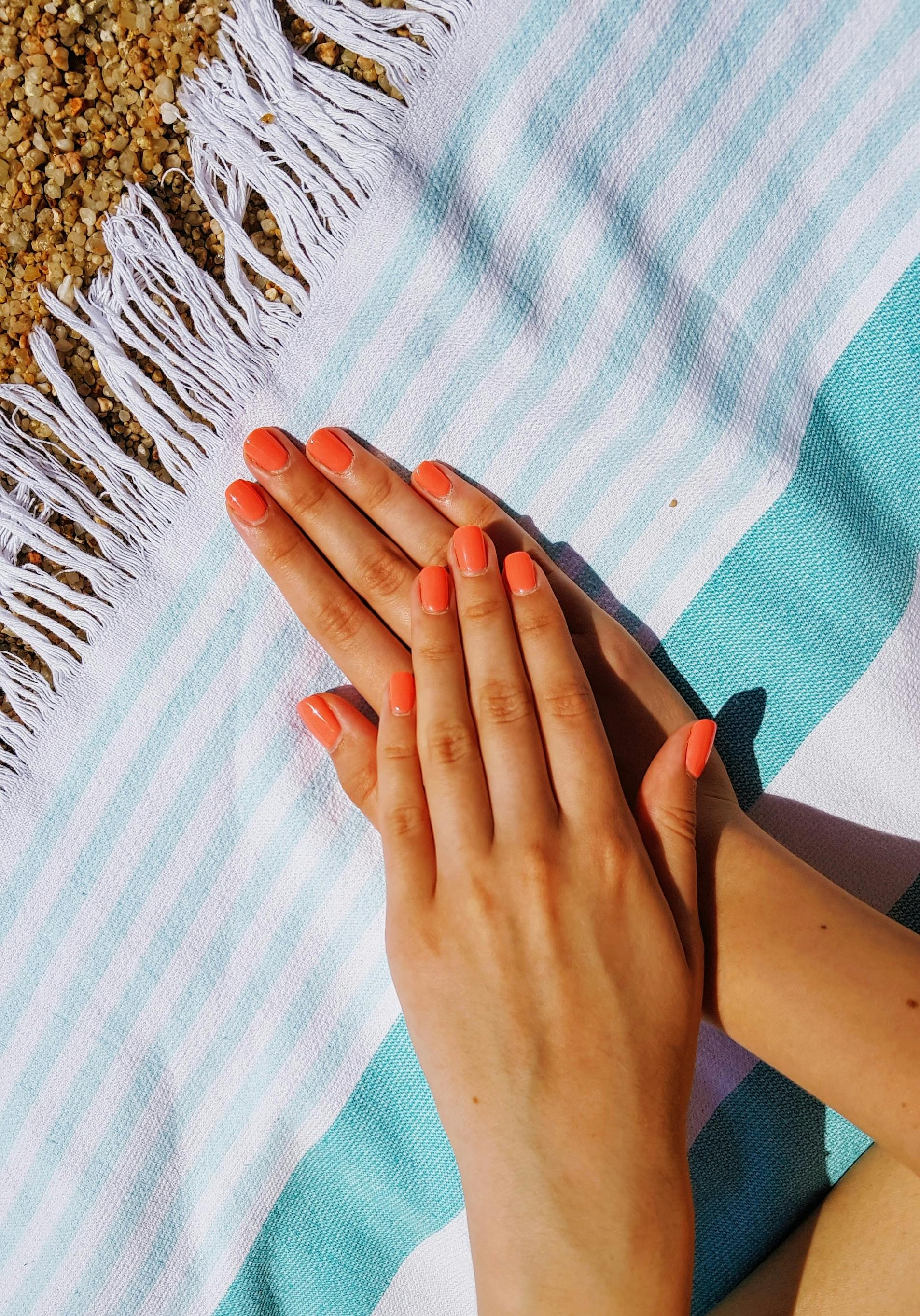 Orange negle på strandhåndklæde